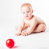 Bebe avec une balle rouge. Portrait.