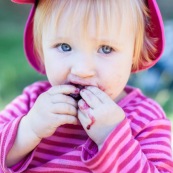 Bebe petite fille enfant en train de manger des cerises. Bouche sale.