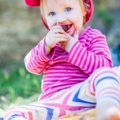 Bebe petite fille enfant en train de manger des cerises. Bouche sale.