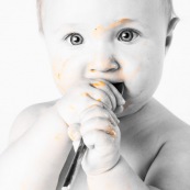 Portrait de bebe en train de manger une mangue de Guyane.