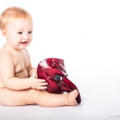 Portrait de bebe avec un masque rouge venitien. Italien. Masque de bal de carnaval. En Guyane.