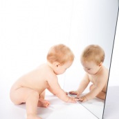 Portrait de bebe avec un miroir. Il se regarde dans la glace.