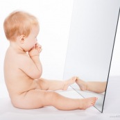 Portrait de bebe avec un miroir. Il se regarde dans la glace.