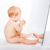 Portrait de bebe avec un miroir. Il se regarde dans la glace.