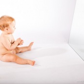 Portrait de bebe avec un miroir. Il se regarde dans la glace.