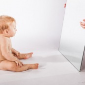 Portrait de bebe avec un miroir. Il se regarde dans la glace.