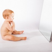 Portrait de bebe avec un miroir. Il se regarde dans la glace.