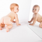 Portrait de bebe avec un miroir. Il se regarde dans la glace.