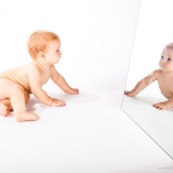 Portrait de bebe avec un miroir. Il se regarde dans la glace.