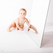 Portrait de bebe avec un miroir. Il se regarde dans la glace.