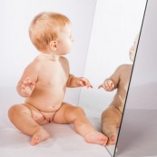 Portrait de bebe avec un miroir. Il se regarde dans la glace.