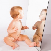 Portrait de bebe avec un miroir. Il se regarde dans la glace.