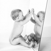 Portrait de bebe avec un miroir. Il se regarde dans la glace.