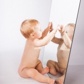 Portrait de bebe avec un miroir. Il se regarde dans la glace.