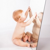 Portrait de bebe avec un miroir. Il se regarde dans la glace.