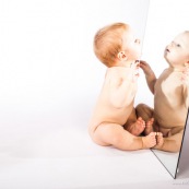 Portrait de bebe avec un miroir. Il se regarde dans la glace.