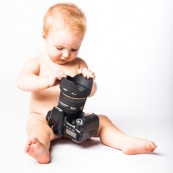 Portrait de bebe avec un appareil photo, en train de prendre des photos. Bebe photographe.