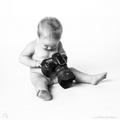 Portrait de bebe avec un appareil photo, en train de prendre des photos. Bebe photographe.