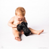 Portrait de bebe avec un appareil photo, en train de prendre des photos. Bebe photographe.