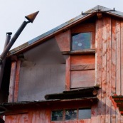 Vue d'une partie du refuge de Bracaciu en Roumanie, dans les montagnes Fagaras. chalet de montagne en bois peint en rouge, cheminÈe du poele toute tordue. Petite fenÍtre et tole rouillÈe.