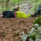 Randonneuse (randonneur) en bivouac ‡ mÍme le sol, en forÍt l'ÈtÈ. Femme allongÈe en train de dormir en forÍt, avec son sac ‡ dos posÈ ‡ cotÈ d'elle, sur un lit de feuille morte. Sieste aprËs l'effort. 

Aux abords du Parc National des Abruzzes en Italie.