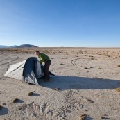 Sur un lac asseche, pres d'Oruro. Camping sauvage, tente. Femme au premier plan.