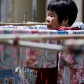 A hong-kong en Chine, femme en train d'etendre son linge dans la rue.