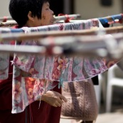 A hong-kong en Chine, femme en train d'etendre son linge dans la rue.